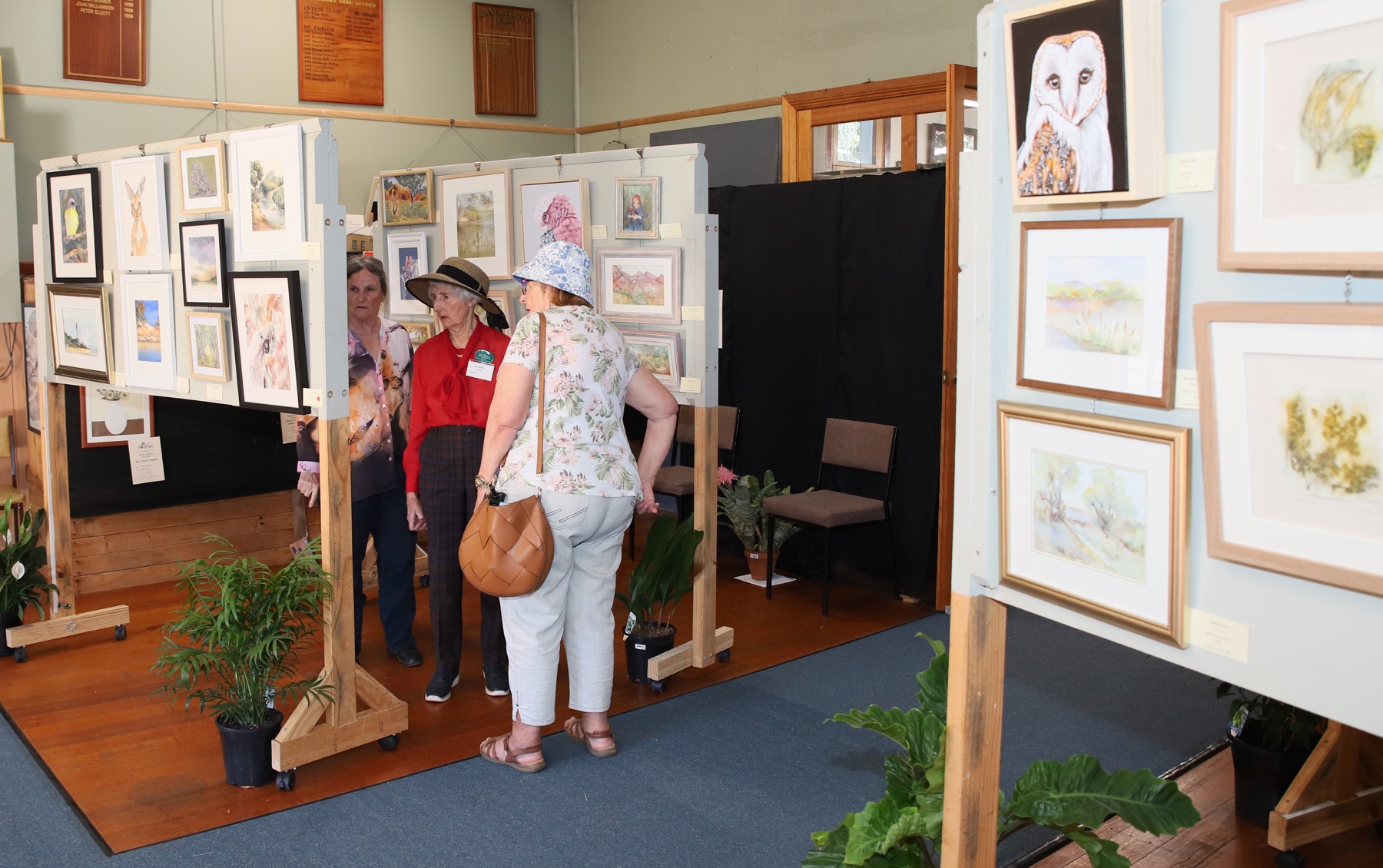 Visitors browsing framed artworks at the Applefest art show